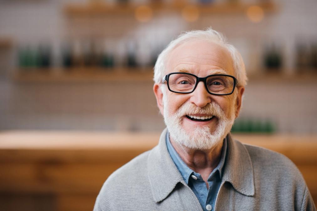 Smiling older man with white hair, beard, and glasses.