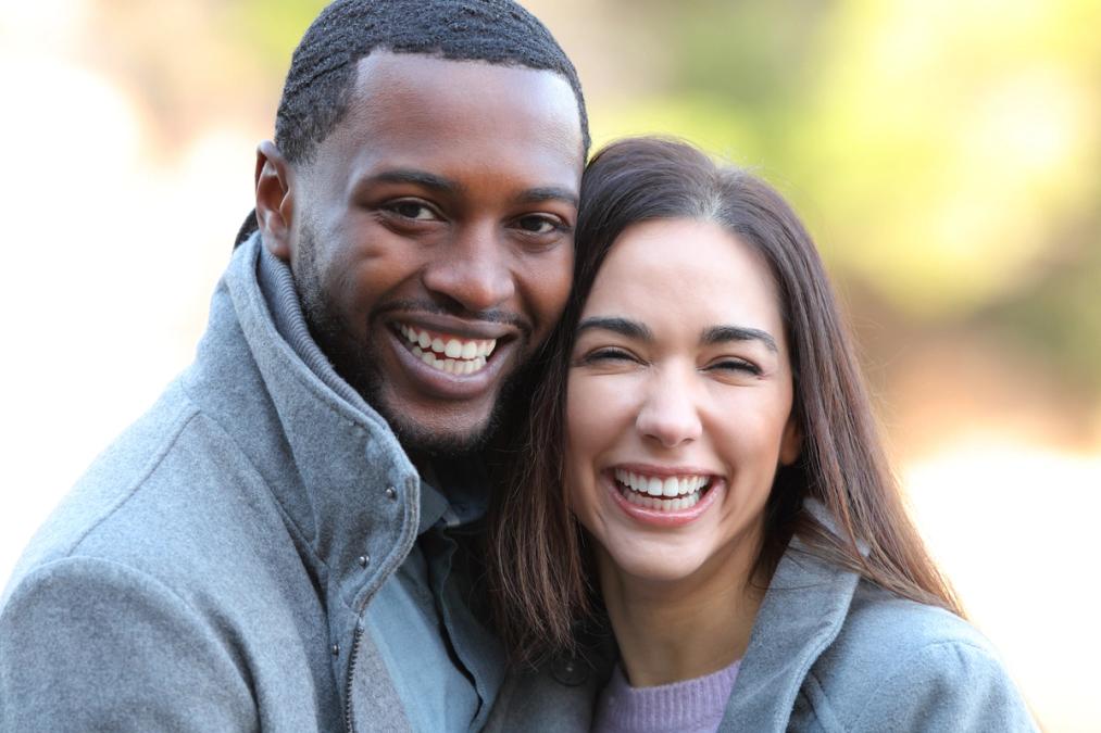 A smiling Black man and a laughing White woman.